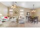 Bright living room featuring high ceilings, a ceiling fan, and comfortable seating with a seamless flow to the dining area at 6713 E Riverdale St, Mesa, AZ 85215