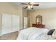 This comfortable main bedroom features tile floors, a ceiling fan and closet doors at 6713 E Riverdale St, Mesa, AZ 85215