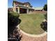 Expansive backyard with manicured lawn, covered patio, and desert landscaping at 6967 W Potter Dr, Glendale, AZ 85308