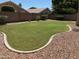 Beautifully landscaped backyard featuring a lush lawn and decorative rock border at 6967 W Potter Dr, Glendale, AZ 85308