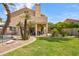 Expansive backyard with lush green lawn, mature landscaping, pool, and covered patio at 7015 W Behrend Dr, Glendale, AZ 85308