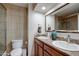Well-lit bathroom features double sinks, tile flooring and a large mirror enhancing the functionality at 7015 W Behrend Dr, Glendale, AZ 85308