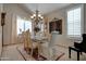 Bright dining room with chandelier, large windows, and a glass-top dining table with seating for six at 7015 W Behrend Dr, Glendale, AZ 85308