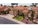 Aerial view of a two-story home with a red tile roof, a three-car garage and well-manicured landscaping at 7015 W Behrend Dr, Glendale, AZ 85308