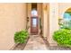 Inviting front entry with a decorative glass front door, and manicured landscaping at 7015 W Behrend Dr, Glendale, AZ 85308