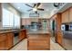 Well-lit kitchen with granite countertops, stainless steel appliances, and custom cabinetry at 7015 W Behrend Dr, Glendale, AZ 85308