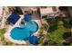Aerial view of a backyard with a pool, spa, patio, umbrellas, and lush landscaping at 7015 W Behrend Dr, Glendale, AZ 85308