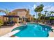 Gorgeous backyard with a sparkling pool, mature palm trees, and outdoor seating areas for entertaining at 7015 W Behrend Dr, Glendale, AZ 85308