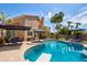 Backyard oasis featuring a large pool, spa, patio, and lush landscaping at 7015 W Behrend Dr, Glendale, AZ 85308