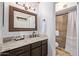 Bathroom featuring granite countertops, an ornate mirror, modern fixtures, and a tiled walk-in shower at 8055 E Thomas Rd # B208, Scottsdale, AZ 85251