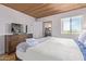Comfortable bedroom featuring a king bed, wood floors, a flat-screen TV, and a view of the bathroom at 8055 E Thomas Rd # B208, Scottsdale, AZ 85251