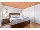 A spacious bedroom with a king-size bed, a wood-paneled ceiling, and ample closet space at 8055 E Thomas Rd # B208, Scottsdale, AZ 85251