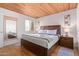 A bedroom with a king bed, wood-style floors, natural light from the window, and a convenient mirror at 8055 E Thomas Rd # B208, Scottsdale, AZ 85251
