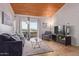 Bright living room with a vaulted ceiling, sofa, chair, and balcony access at 8055 E Thomas Rd # B208, Scottsdale, AZ 85251