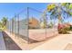 A gated tennis court with a green and red surface surrounded by greenery at 8055 E Thomas Rd # B208, Scottsdale, AZ 85251