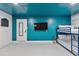 Finished basement with door and TV featuring bunk beds and electric blue accents at 8707 E Clarendon Ave, Scottsdale, AZ 85251