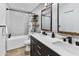Bright bathroom featuring a dual sink vanity, hexagon tile, and a shower-tub combo at 8707 E Clarendon Ave, Scottsdale, AZ 85251