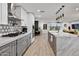 Large kitchen with gray and white cabinets, marble countertops, wood floors, and a big center island at 8707 E Clarendon Ave, Scottsdale, AZ 85251