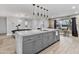 Spacious kitchen with an island, marble countertop, pendant lights, and stylish finishes and details at 8707 E Clarendon Ave, Scottsdale, AZ 85251
