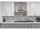 Kitchen backsplash and cabinets with stainless steel hood range at 8707 E Clarendon Ave, Scottsdale, AZ 85251