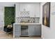 Custom wet bar features modern cabinetry, granite counters, a beverage cooler, and stylish decor at 8707 E Clarendon Ave, Scottsdale, AZ 85251