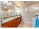 Bathroom featuring double sinks, granite countertop, warm wood cabinetry, and great lighting at 8880 E Paraiso Dr # 118, Scottsdale, AZ 85255