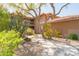 Inviting condo exterior with desert landscaping and a walkway leading to the entrance and a mature tree at 8880 E Paraiso Dr # 118, Scottsdale, AZ 85255