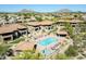 Aerial view of a community pool with lounge chairs, tables, and desert views in the background at 8880 E Paraiso Dr # 118, Scottsdale, AZ 85255