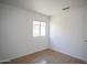 Bright bedroom with wood-look flooring, a window, and neutral paint throughout at 12205 N 41St Ln, Phoenix, AZ 85029