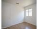 Clean bedroom with wood-look flooring, a window, door and neutral paint throughout at 12205 N 41St Ln, Phoenix, AZ 85029
