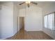 Bright bedroom features high ceilings, wood floors, a window, and a door leading to the hallway at 12205 N 41St Ln, Phoenix, AZ 85029