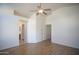 Open bedroom featuring wood floors, ceiling fan, bathroom entrance, and closet access at 12205 N 41St Ln, Phoenix, AZ 85029