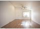 Bright, spacious living room featuring wood floors, a ceiling fan, and a large window for natural light at 12205 N 41St Ln, Phoenix, AZ 85029