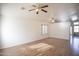 Spacious living room featuring wood floors, two ceiling fans, and natural light from the window at 12205 N 41St Ln, Phoenix, AZ 85029