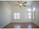 Bright living room with wood floors, a ceiling fan, and large windows, creating a welcoming atmosphere at 12205 N 41St Ln, Phoenix, AZ 85029