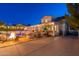 Backyard view of a home at dusk, with an outdoor kitchen, a fire pit, string lights overhead, and manicured landscaping at 1379 S Claiborne Ave, Gilbert, AZ 85296