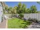 Lush green backyard featuring a well-maintained lawn and a charming white picket fence at 1379 S Claiborne Ave, Gilbert, AZ 85296