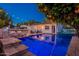 Beautiful backyard featuring a pool, bar seating, string lights, and well-manicured trees at 1379 S Claiborne Ave, Gilbert, AZ 85296