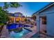 Stunning backyard showcasing a pool, spa, outdoor kitchen, and comfortable lounge area under string lights at 1379 S Claiborne Ave, Gilbert, AZ 85296