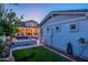 Backyard oasis featuring a sparkling pool with stone accents and a view of the well-lit home at 1379 S Claiborne Ave, Gilbert, AZ 85296