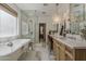 Bright bathroom featuring a soaking tub, frameless shower, and and vanity areas with pendant lighting at 1379 S Claiborne Ave, Gilbert, AZ 85296