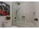 Bright bathroom featuring a bathtub with a shower, neutral tile, and modern fixtures at 1379 S Claiborne Ave, Gilbert, AZ 85296