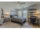 Well-lit bedroom features a bed, ceiling fan, study area, and stylish decor, creating a cozy retreat at 1379 S Claiborne Ave, Gilbert, AZ 85296