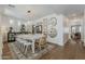 Bright dining room with a long table, multiple mirrors on the wall, and wood flooring at 1379 S Claiborne Ave, Gilbert, AZ 85296