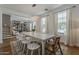 Bright dining room with a long table, modern chandelier, and staircase to the second floor at 1379 S Claiborne Ave, Gilbert, AZ 85296