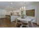 Open-concept dining area connected to the kitchen features a round table, chandelier, and breakfast bar at 1379 S Claiborne Ave, Gilbert, AZ 85296