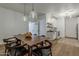 Open dining room with hardwood floors, pendant lights, and access to laundry room at 1379 S Claiborne Ave, Gilbert, AZ 85296