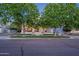 Inviting home with a charming front porch, mature trees, and well-maintained landscaping at 1379 S Claiborne Ave, Gilbert, AZ 85296