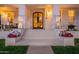 Charming front entrance featuring a brick facade, decorative lighting, and potted flowers on the steps at 1379 S Claiborne Ave, Gilbert, AZ 85296