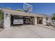 Large three-car garage with a basketball hoop, vehicles, and a paved driveway and backyard at 1379 S Claiborne Ave, Gilbert, AZ 85296